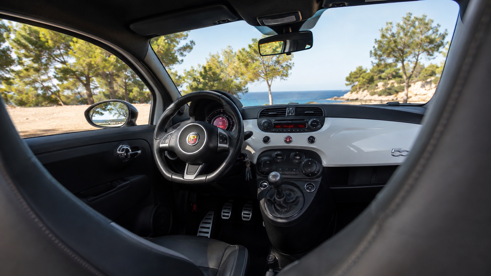 Abarth 500-interiør set skråt fra højre bagsæde med instrumenter og original radio tændt