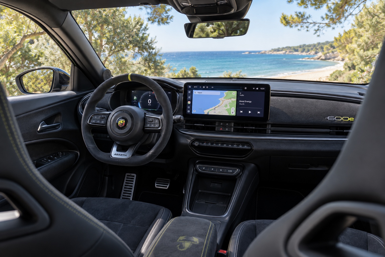 Interiøret i Abarth 600e Competizione med sportsrat, digitale instrumenter og tændt multimedieskærm