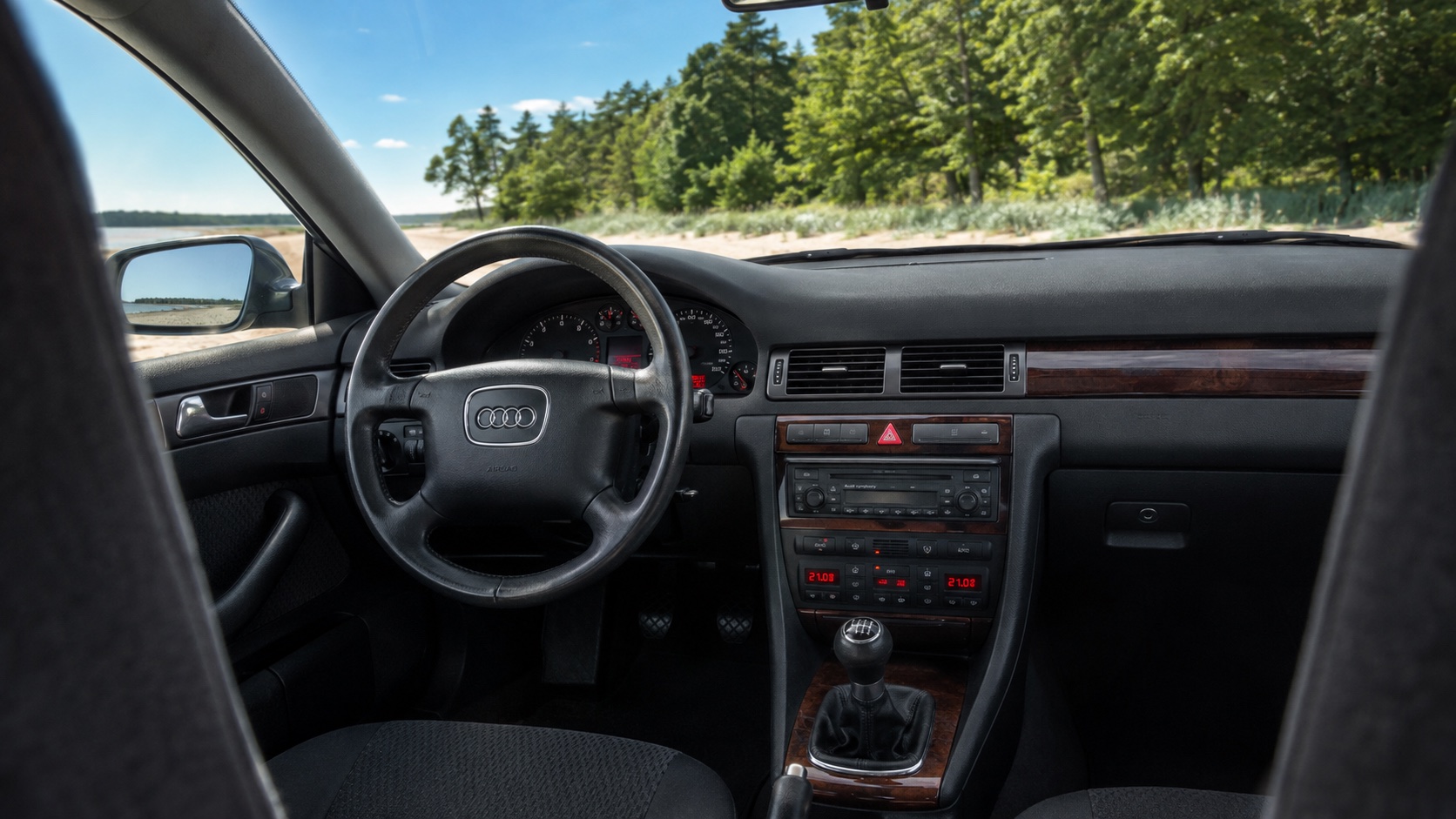 Audi A6 C5-interiør med oplyste instrumenter, original radio og klimadisplays