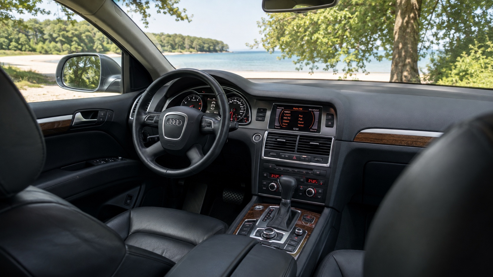Audi Q7 4L-interiør set skråt fra højre bagsæde med instrumenter og MMI tændt