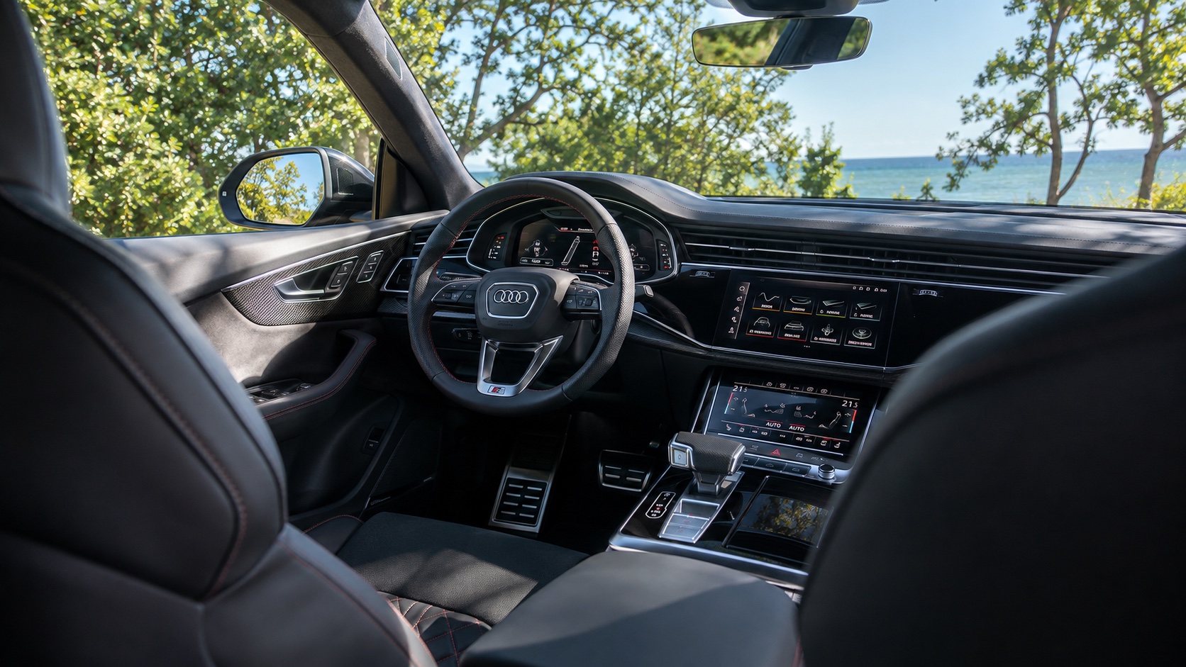 Audi SQ8-interiør set skråt fra højre bagsæde med instrumenter og MMI-skærme tændt