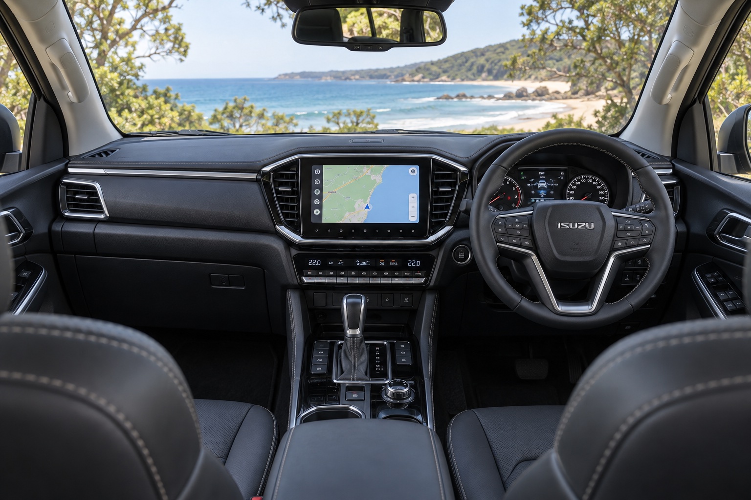 Højrestyret Isuzu MU-X med tændt navigationsskærm og fysiske klimaknapper set fra højre bagsæde