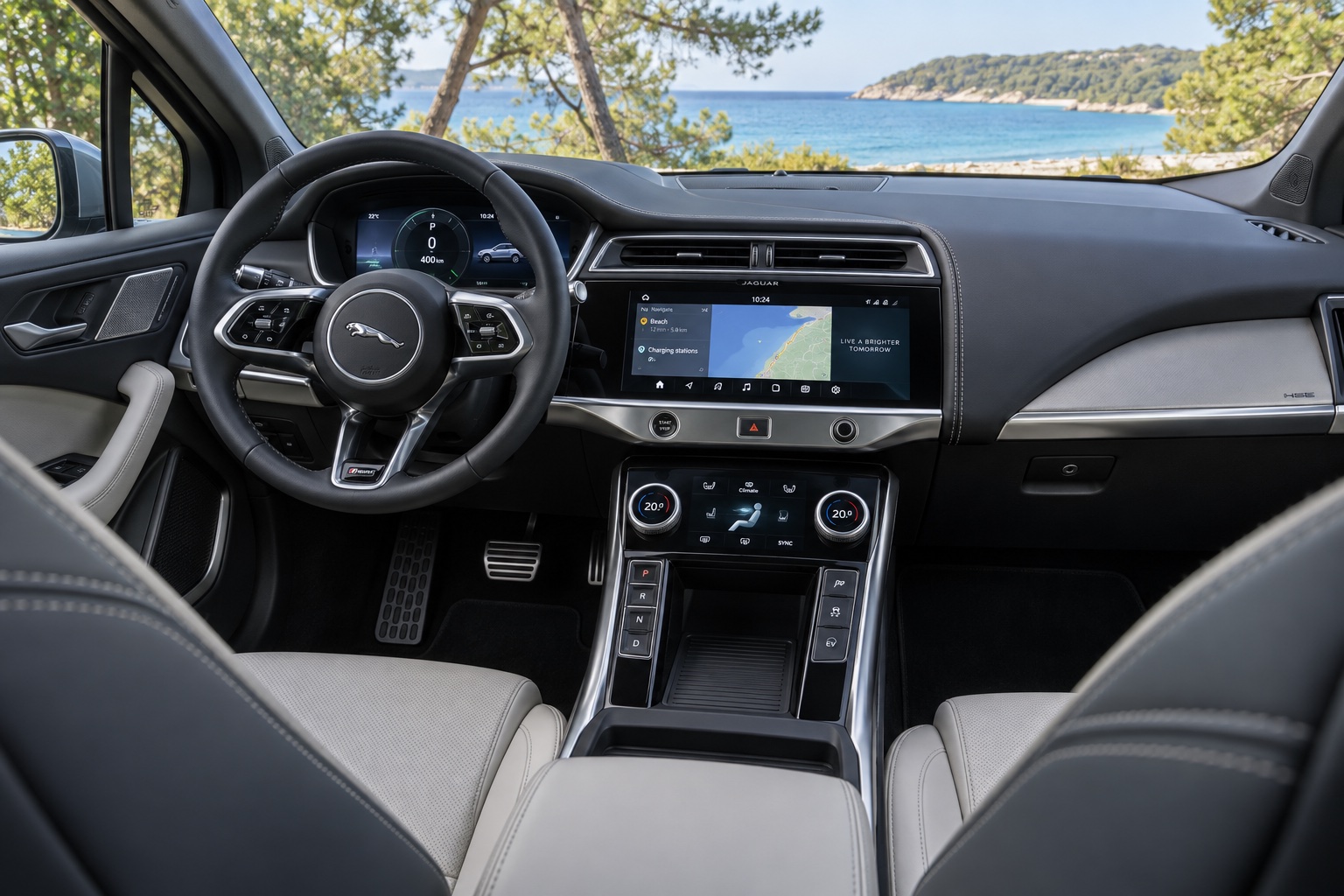 Jaguar I-PACE med digital instrumentering og to tændte midterskærme set fra højre bagsæde